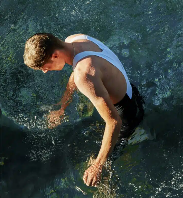 man dipping his hands in water